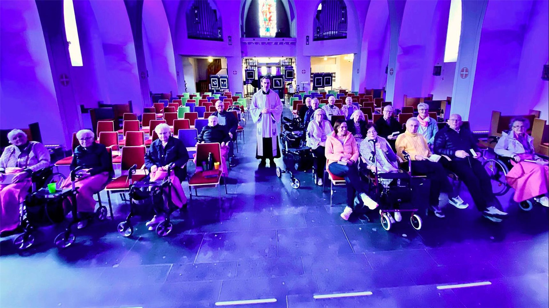 Blick auf die Zuschauenden in der Kirche, in der Mitte steht der Pfarrer