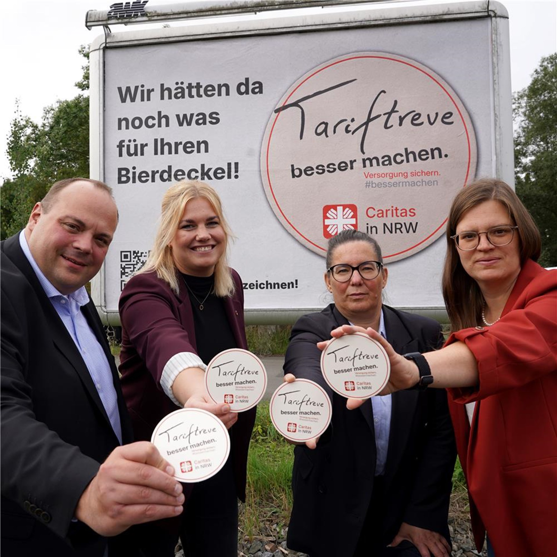 Dominik Pieper, Hanna Twyhues, Esther van Bebber und Andrea Klausing halten die Kampagnen-Bierdeckel in die Kamera