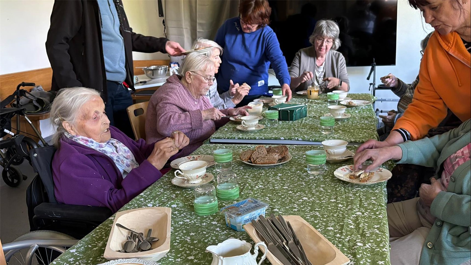 Senioren und Seniorinnen sitzen am Tisch bei Kaffee und Kuchen